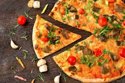 Pizzabakker die deeg draait in de keuken van Pizzeria Mafia