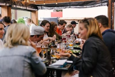 Groep vrienden die pizza deelt aan tafel bij Pizzeria Mafia