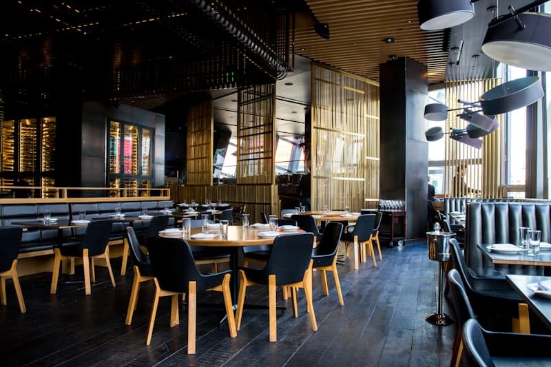 Het interieur van Pizzeria Mafia met donkere muren, neonverlichting en een open keuken