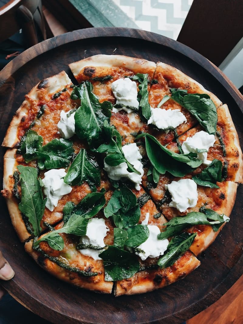 Close-up van vers pizzadeeg dat wordt gekneed op een met bloem bestoven werkblad
