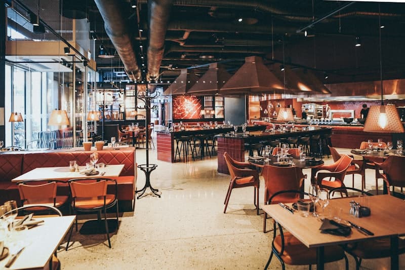 Het interieur van Pizzeria Mafia met de houtoven op de achtergrond en warm neonlicht